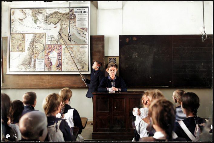 Oppilas näyttää 1900-luvun alkupuolella kartalta Välimeren. Kuvalähde: Helsingin kaupungin museo. Väritetty MyHeritagen In Colorilla